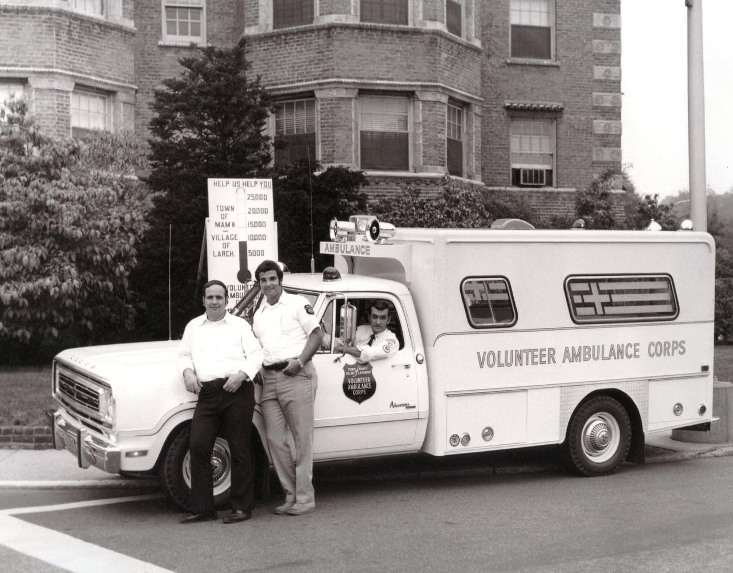 Larchmont VAC members posed with the corps' early ambulance and a hand-painted fundraising sign